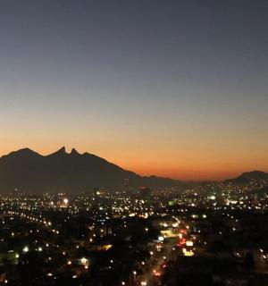 a view of a city at night with a mountain