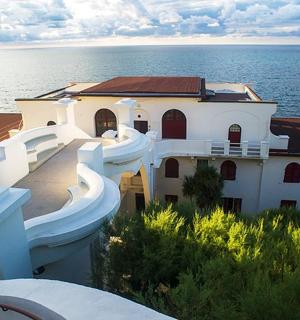 un gran edifici blanc amb l'oceà al fons