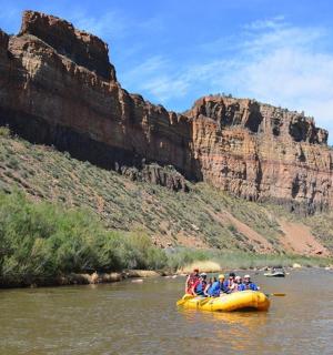 skupina ljudi, ki se spuščajo po reki s splavom