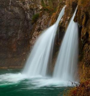 et vandfald på siden af en klippefyldt klippe