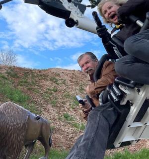 a man sitting on a motorcycle with a statue of a bull