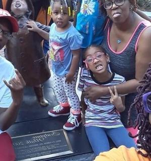 skupina lidí stojících před sochou