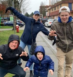 a group of people standing on a sidewalk with their arms out