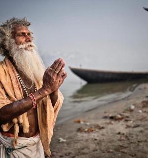 一位留着长胡子的男子站在水边