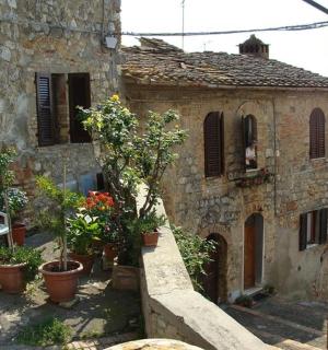 an old stone building with potted plants and a chair