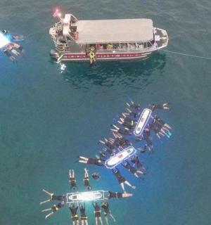 a group of people in the water next to a boat