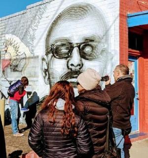 a group of people standing in front of a mural