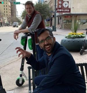 a man sitting on a bench next to two scooters