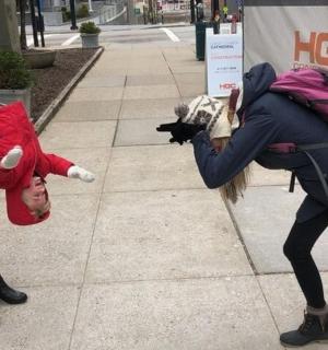 žena s kočkou v batohu a osoba držící plyšáka