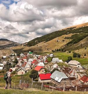 a man standing on a hill looking at a village