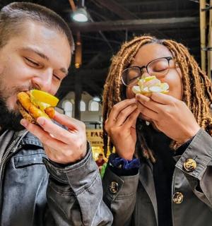 muž a žena jedí párky v rohlíku