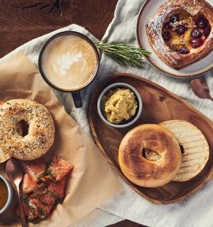 a table with a plate of food with bagels and dips