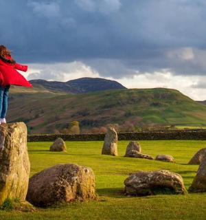 a woman standing on top of rocks in a field
