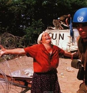 一名女子站在一名戴着头盔的男子旁边