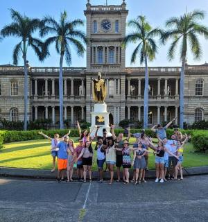 Skupina dětí pózuje před budovou s hodinovou věží