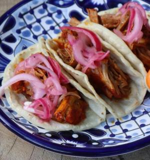 蓝白相间的盘子上放着两份玉米饼,配上辣椒