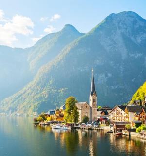 a town next to a body of water with mountains