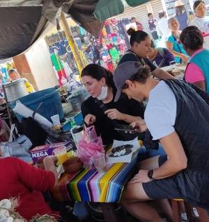 一群人围站在市场里的一张桌子旁