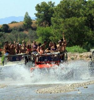 一群人骑在河上游船的后面