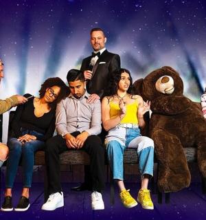 一群人坐在长椅上，身边还有一只泰迪熊