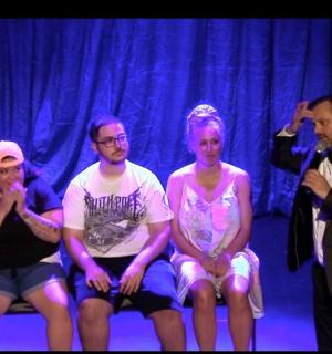 a group of people sitting on a bench on a stage