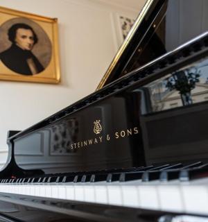 a piano with a picture of a man on the wall