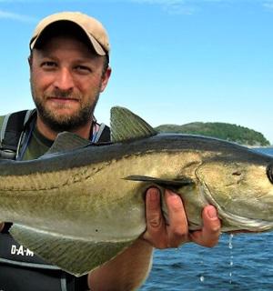 一名男子手里拿着一条大鱼