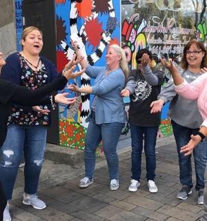 skupina žen stojících na ulici se zdviženýma rukama