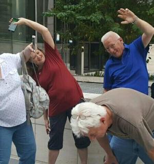 skupina lidí stojící kolem muže, který si fotí