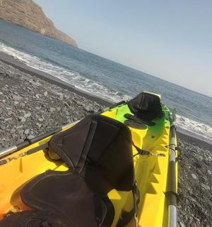 一艘黄色皮划艇停放在水边的沙滩上