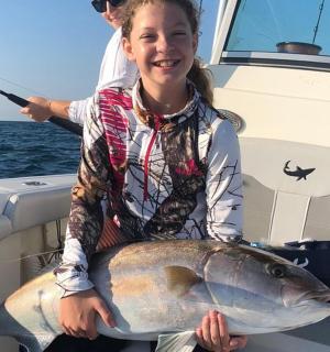 船上抱着大鱼的女孩