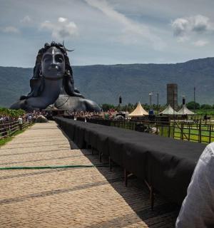 一名男子站在一座巨大的雕像前