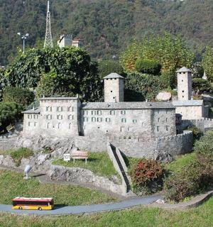 a castle on a hill with a bus on a road