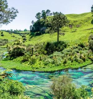 řeka uprostřed zeleného svahu