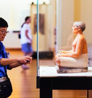 a man standing next to a statue in a museum