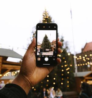 一个人在圣诞树前举着手机