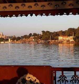 一艘船在水面上行驶，背景是建筑物