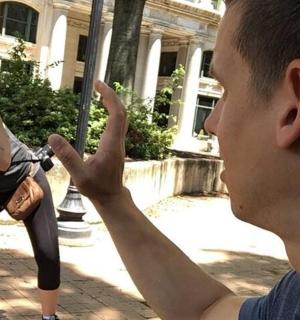 一名男子正在给一名撑着伞的女子拍照