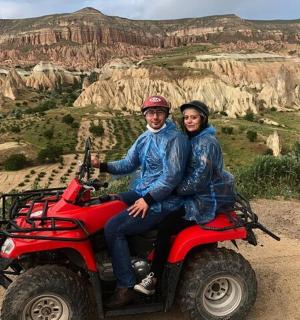 a man and woman riding a red atv in the desert