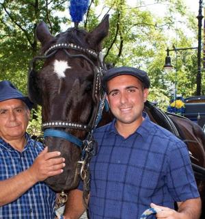 two men standing next to a horse and a carriage