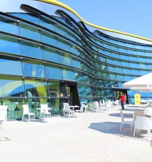 ein Gebäude mit weißen Tischen und Stühlen davor