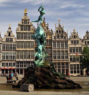 a statue in the middle of a city with buildings