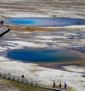 a group of people walking on a bridge over a body of water