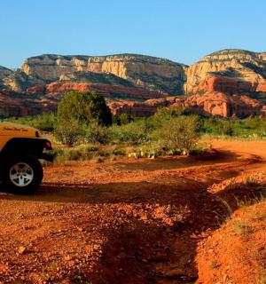 Žlutý nákladní vůz zaparkovaný na prašné cestě v poušti