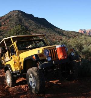 一辆黄色吉普车在土路上行驶