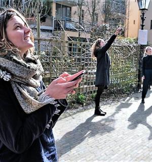 一群妇女站在人行道上看着她们的手机