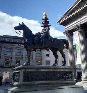 一尊男子骑着一匹头戴圆锥体的马的雕像