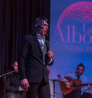 um homem em pé em um palco com um grupo de pessoas