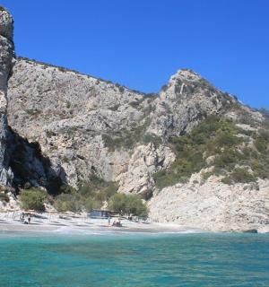 en strand ved siden af et bjerg med mennesker på den