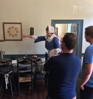 skupina lidí stojících kolem muže v místnosti